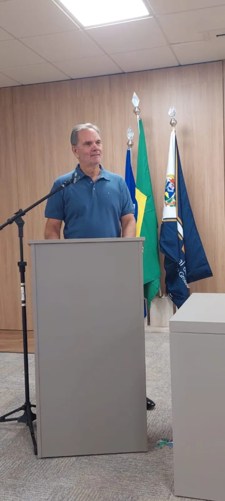 Nelson Cordeiro ao microfone, atrás de um púlpito durante uma palestra.